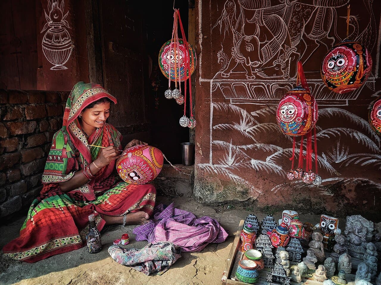 Odisha master artisan in traditional handloom attire hand-painting sacred Pattachitra artwork